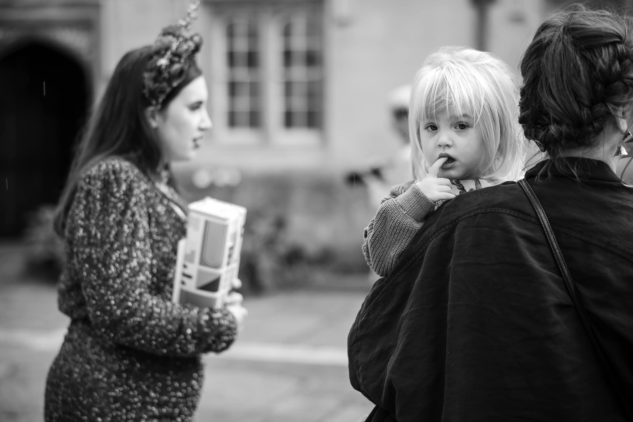 Young child on mothers shoulder at Corpus Christi College Oxford Wedding