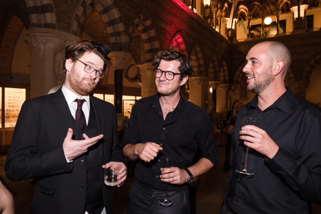 Three Guests joking about at the Oxford Natural History Museum wedding reception