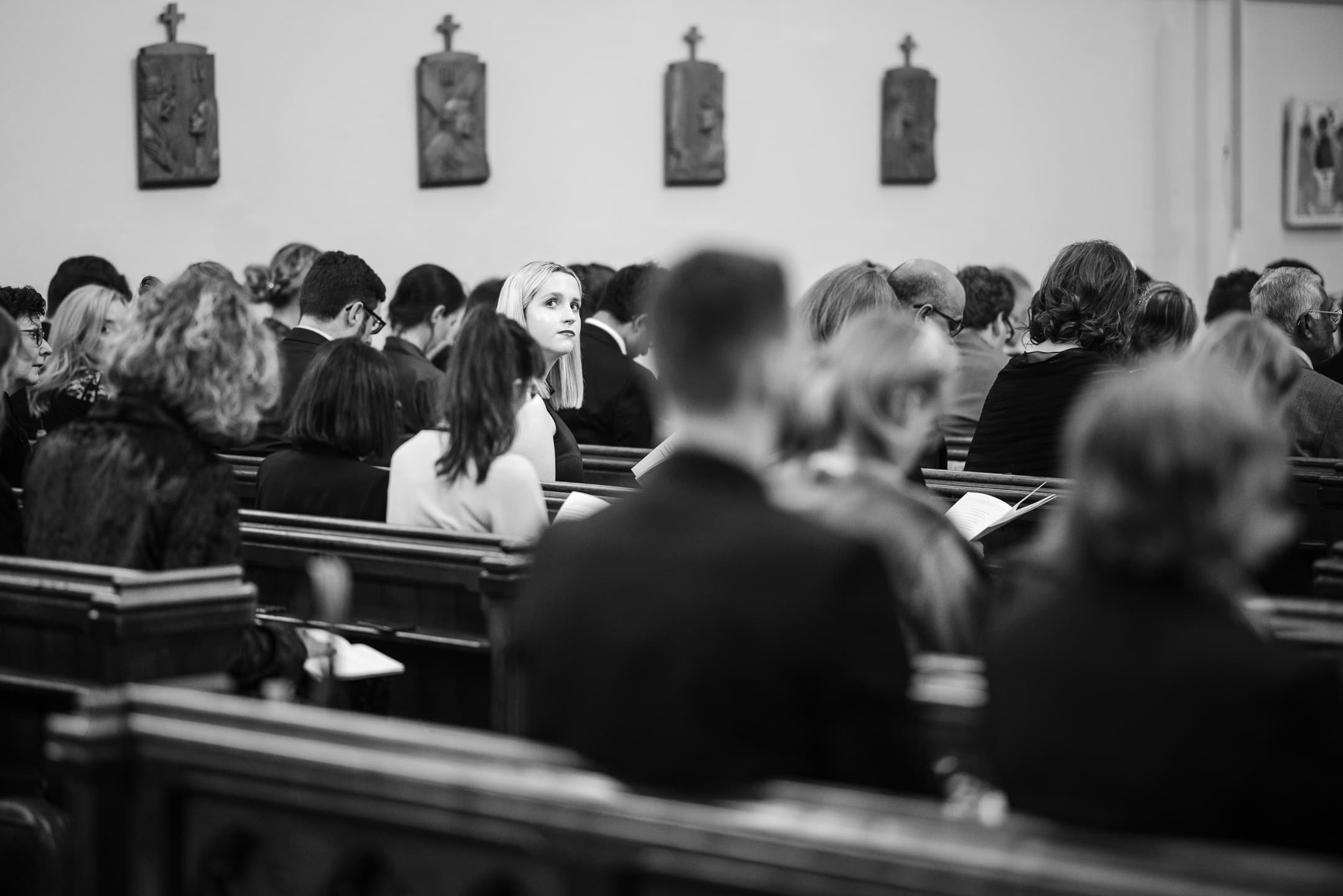 Guest looks back during the wedding service at St Mary Magdalen Church Oxford