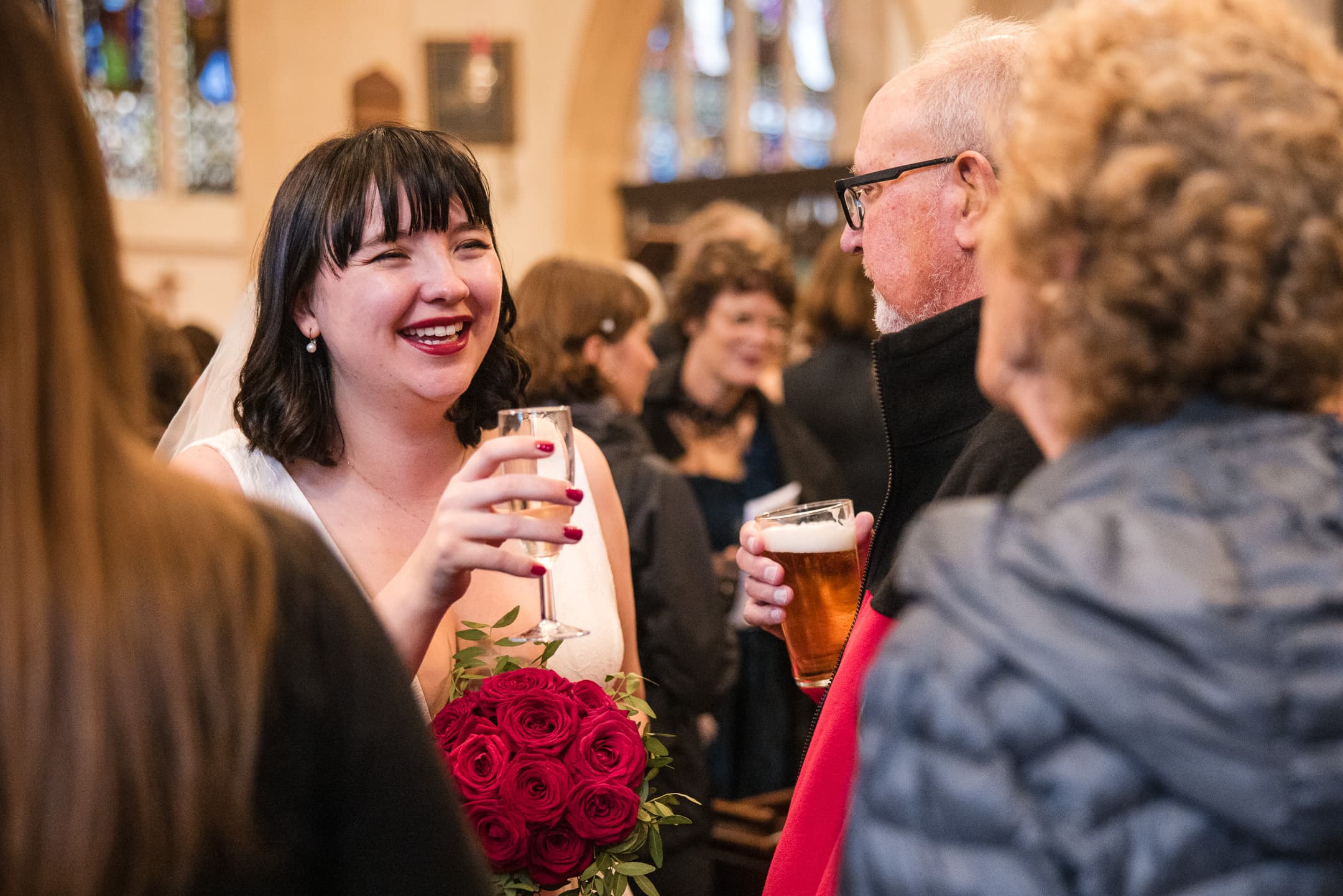 Bride drinking champagne after the ceremony at St Mary Magdalen Church
