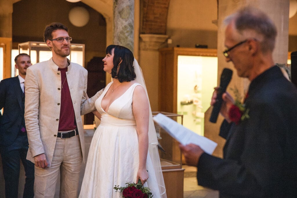 Bride looking at Groom during speeches at the Oxford Natural History Museum
