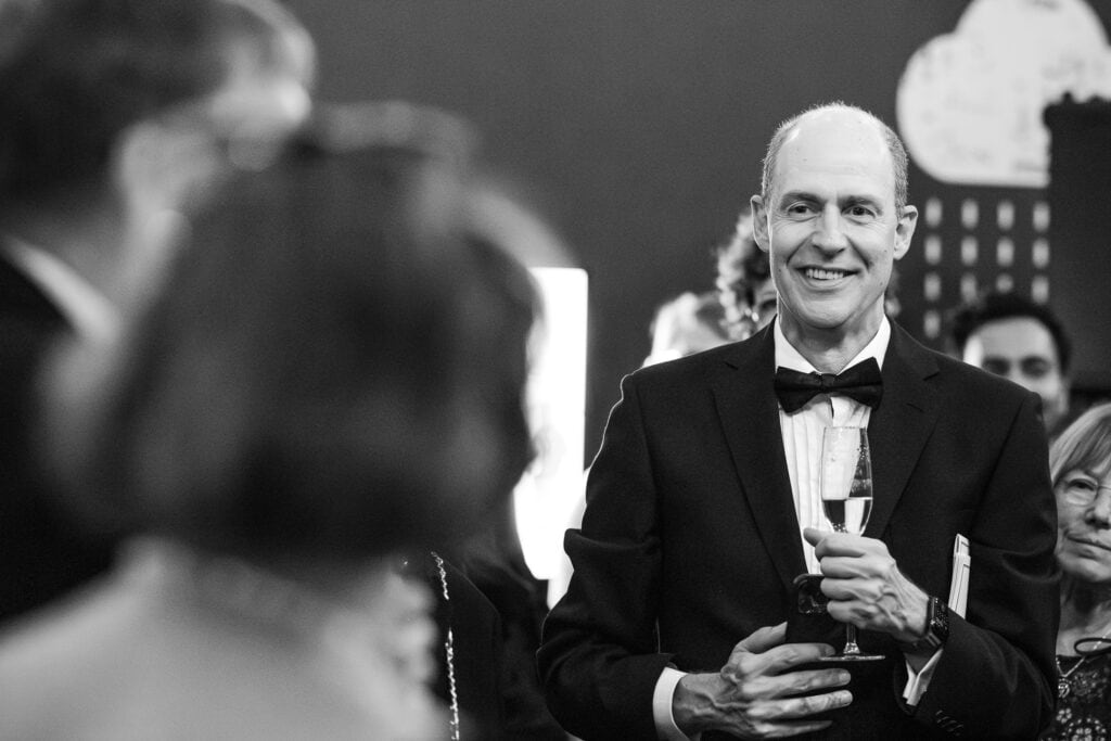 Guest hold a glass of Champagne at the Oxford Natural History Museum wedding reception.