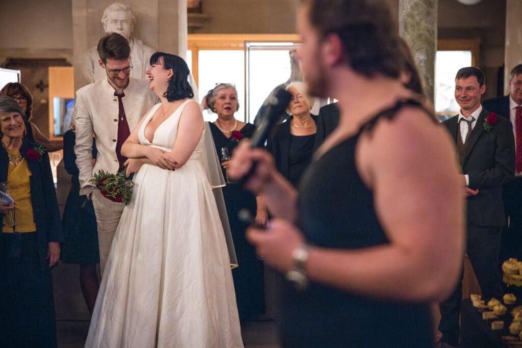 Bride and Groom laughing during speeches at the Oxford Natural History Museum