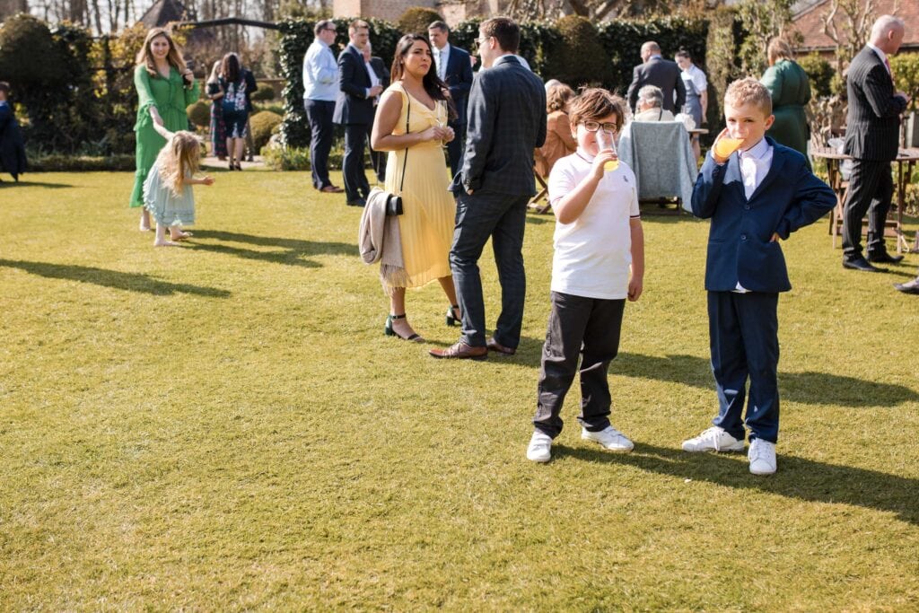 Two young boys drinking orange at wedding