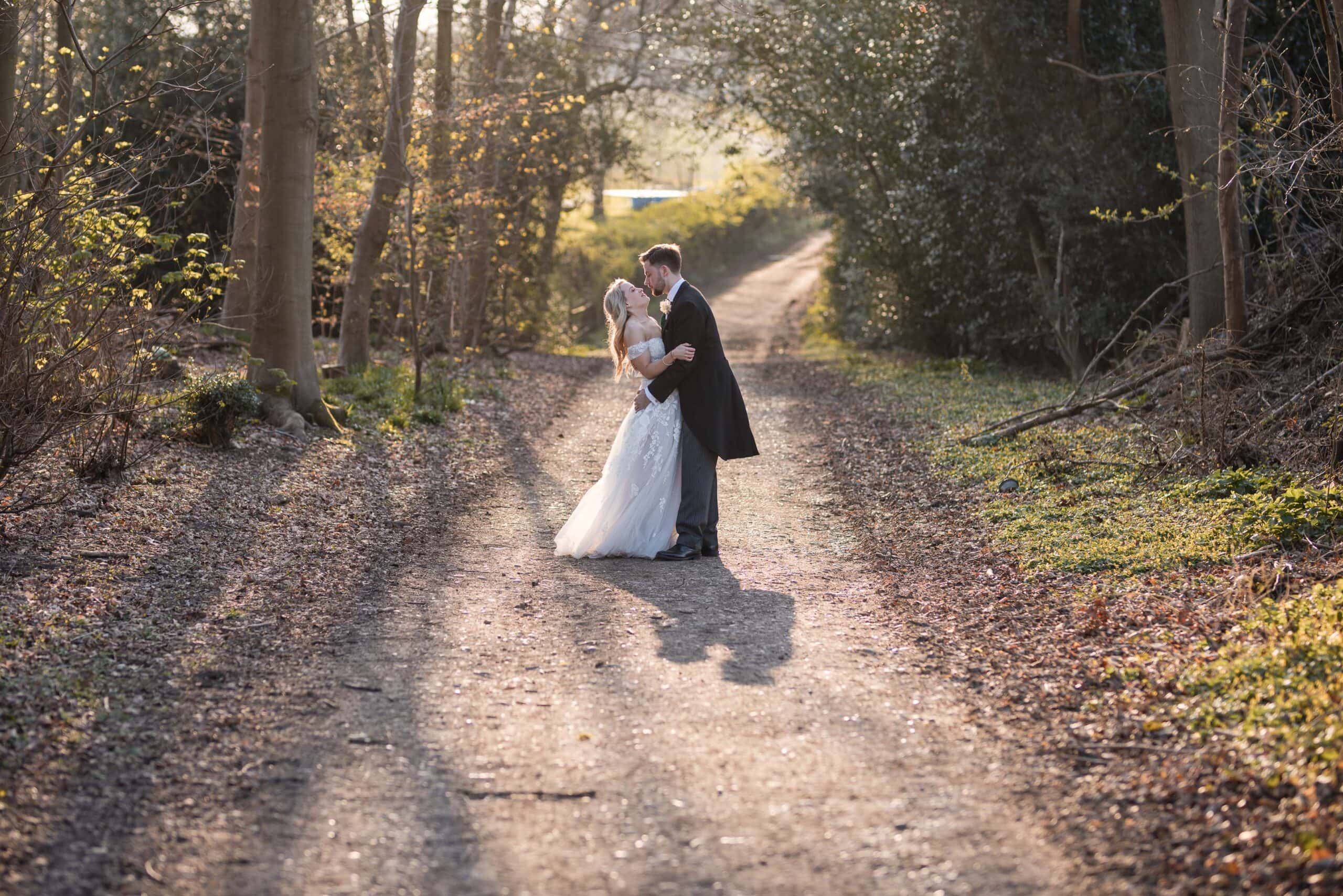 Bride and Groom walking down wooded lane