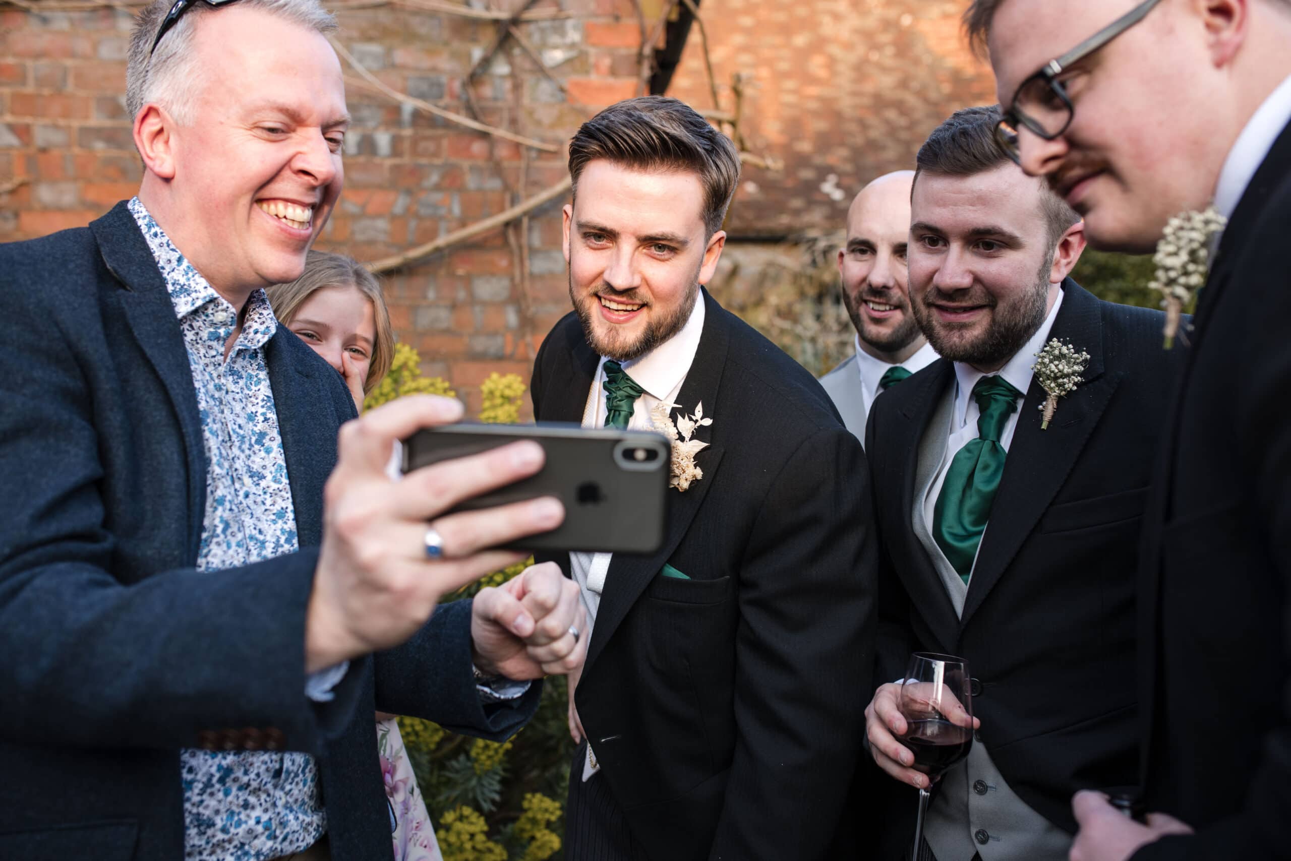 Groom and friends looking at phone