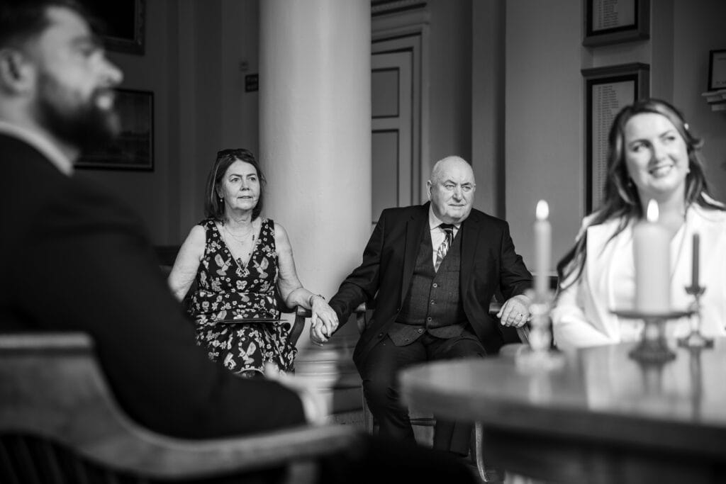 Mother and Father of the bride look on during the Wedding at Woodstock Townhall
