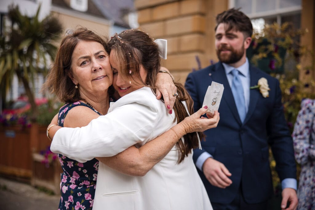 Bride cuddling mother just after being married