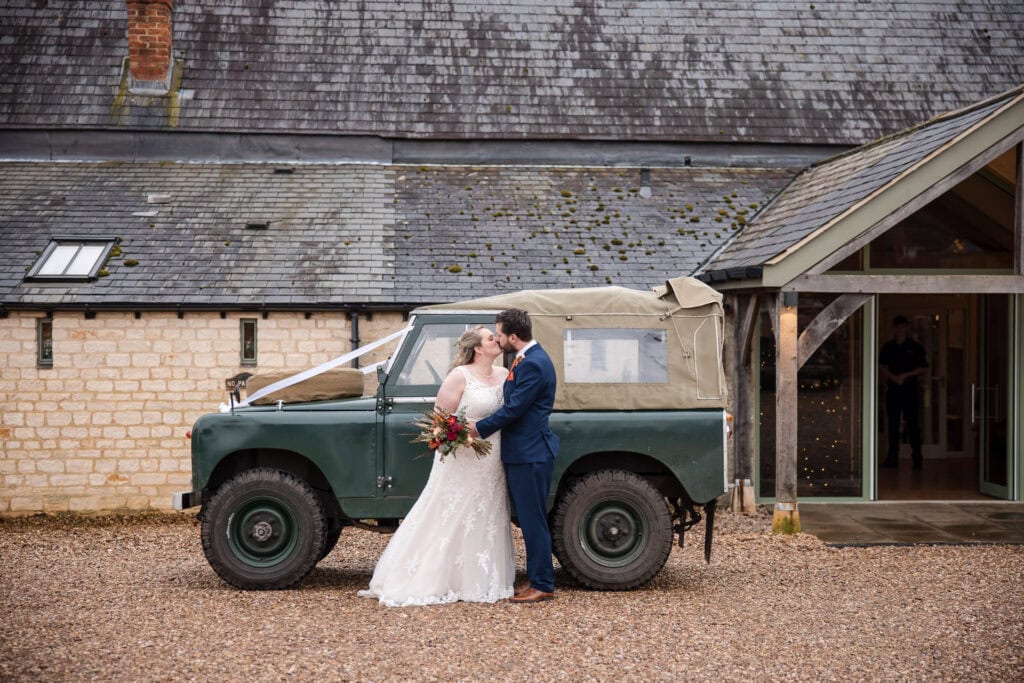 Bride and Groom with landrover at The Great Barn Ayhno